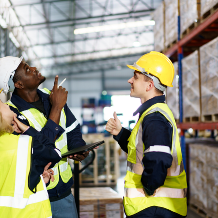 Three safety employees inspecting an issue in the warehouse